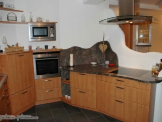 Geschwungener Kochbereich mit fl&auml;chenb&uuml;ndigem Ceranfeld
