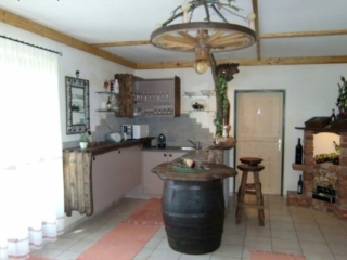 Rustikale Kellerbar mit Eichenfass und Wagenrad als Deckenlampe